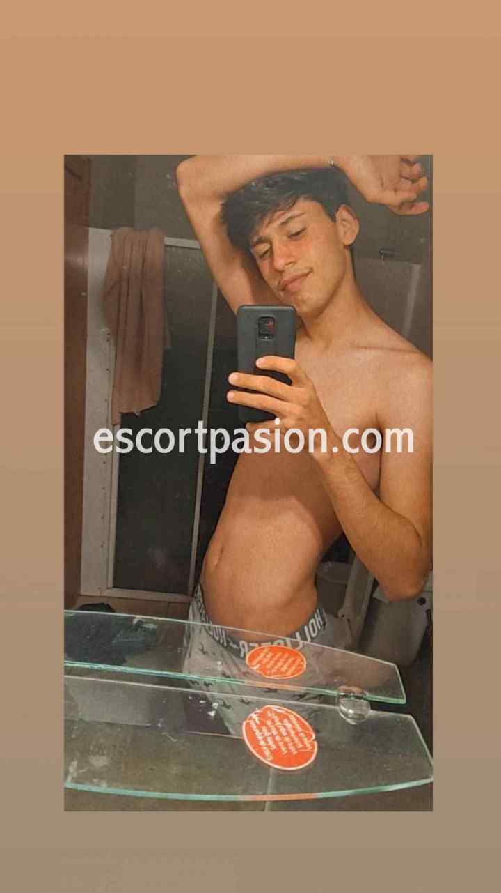 escort gay de cuerpo delgado se hace una selfi en su habitación