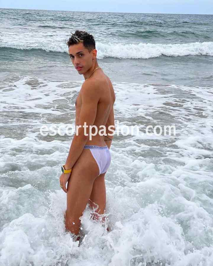 chico gay en la playa disfruta del mar