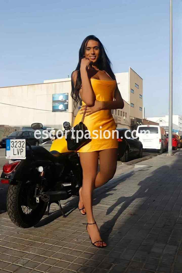 travesita mujer con vestido amarillo posando en la calle